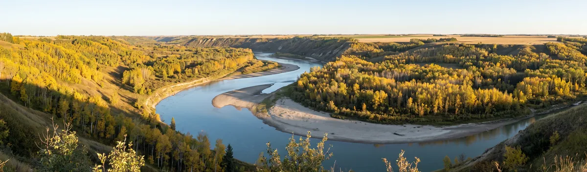 Prairie river curving through a valley at sunrise
